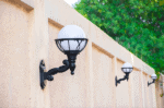Wall side globe lamp with black metal arm and white glass globe.