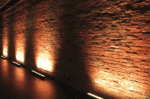LED wall washer illuminating brick wall with warm lighting.
