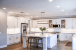 LED COB down light illuminating a bright, modern kitchen with white cabinets and stainless steel