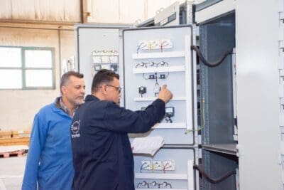 Zwei Techniker prüfen elektrische Geräte in der Werkstatt