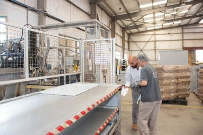 Werksmitarbeiter prüfen Maschinen in der Produktionshalle
